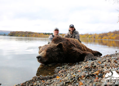 Two hunters with brown bear